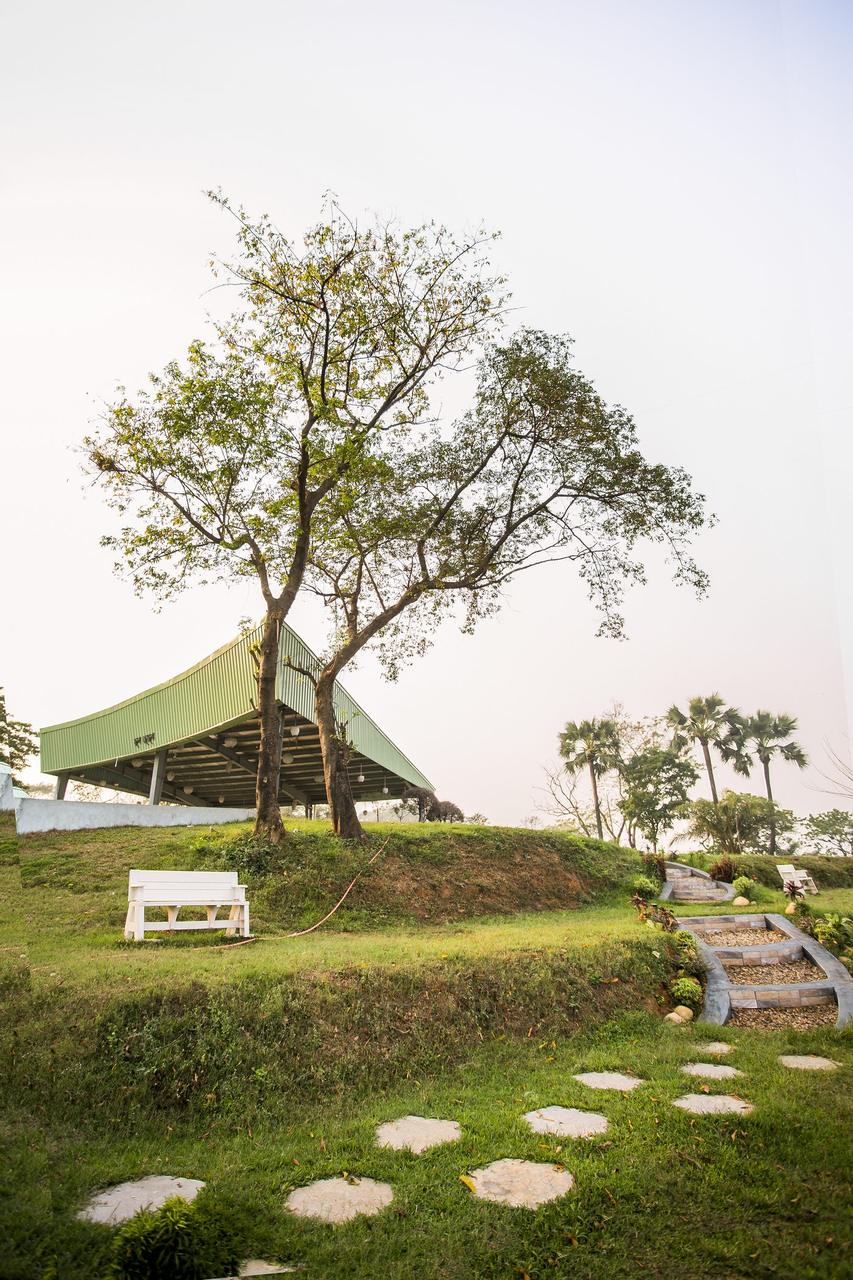 Open-air green-roofed function shed on the grounds